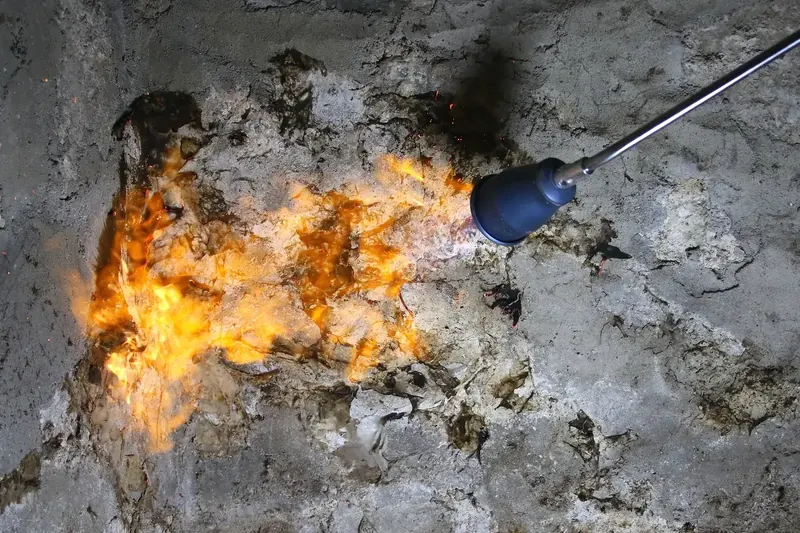Brûlage d'un mur de moellon lors d'un traitement de mérule